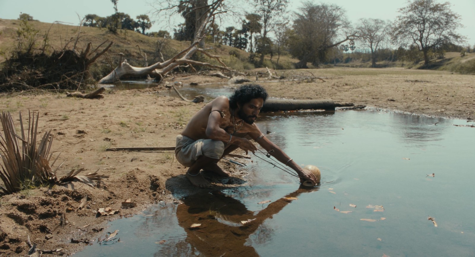 Shankar filling a water-gourd decades later when the stream has reduced to a trickle